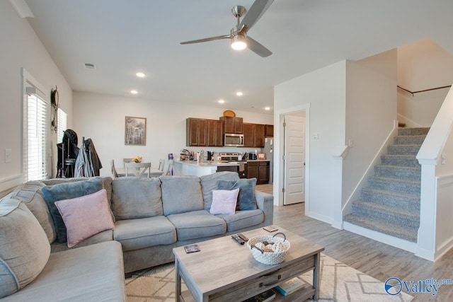 living room with ceiling fan and light hardwood / wood-style floors