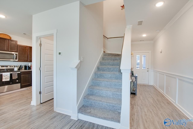 stairway featuring crown molding and wood-type flooring