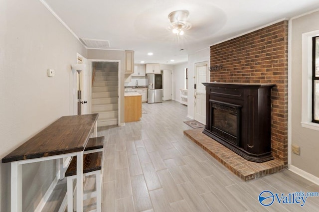 unfurnished living room featuring light wood finished floors, visible vents, and a wealth of natural light