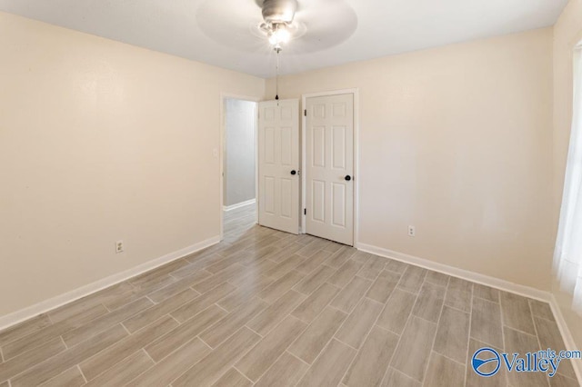 unfurnished room featuring baseboards, a ceiling fan, and light wood-style floors