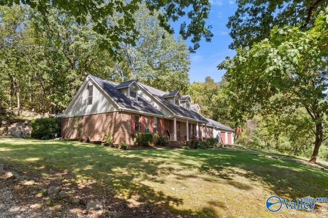 view of side of home with an attached garage, a lawn, and brick siding