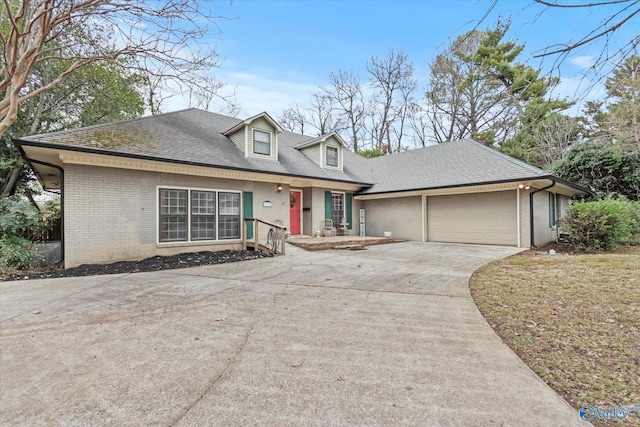 view of front of house featuring a garage, concrete driveway, brick siding, and a shingled roof