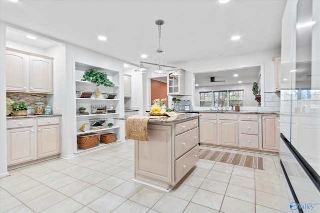 kitchen featuring recessed lighting, a center island, light stone counters, and light tile patterned flooring