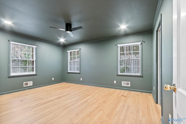 unfurnished room with ornamental molding, wood finished floors, and visible vents