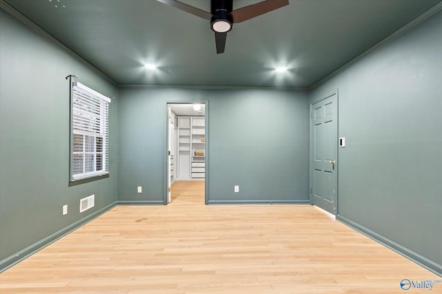 unfurnished room featuring ornamental molding, visible vents, ceiling fan, and wood finished floors