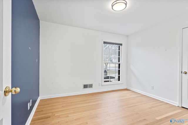 spare room with light wood-type flooring, baseboards, and visible vents