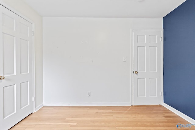 spare room featuring light wood-style flooring and baseboards