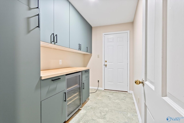 laundry area featuring wine cooler and baseboards