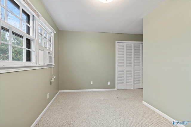 unfurnished bedroom featuring multiple windows, carpet floors, a closet, and baseboards