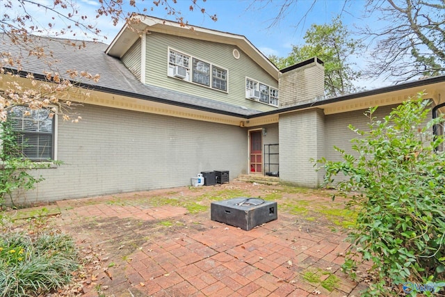 rear view of house featuring a patio area, brick siding, and central air condition unit