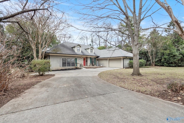 view of front facade featuring driveway, roof with shingles, and an attached garage