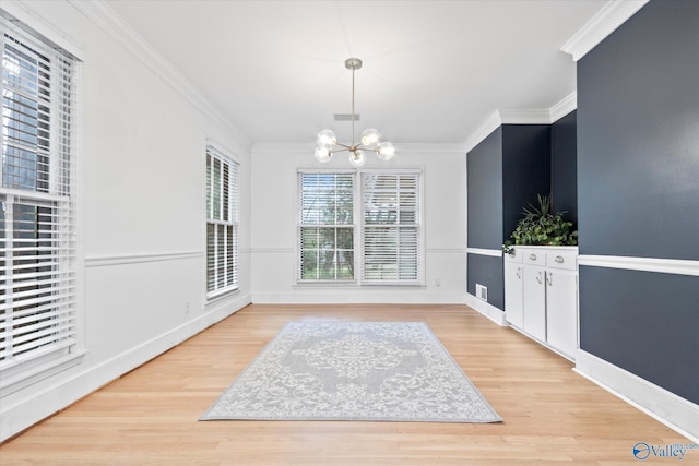 dining area with ornamental molding, light wood-type flooring, visible vents, and a notable chandelier