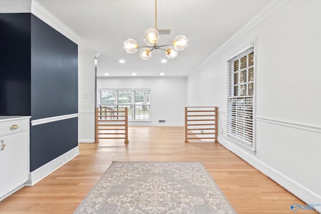 interior space featuring light wood-type flooring, baseboards, a chandelier, and crown molding