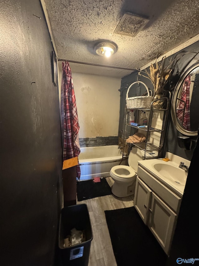 full bath featuring a textured ceiling, wood finished floors, vanity, visible vents, and shower / bath combination with curtain