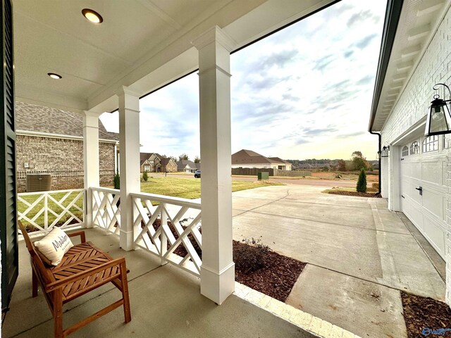 view of patio / terrace featuring a porch and a garage