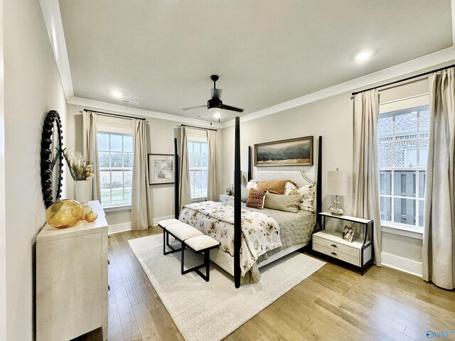 bedroom featuring light hardwood / wood-style floors, ceiling fan, and crown molding