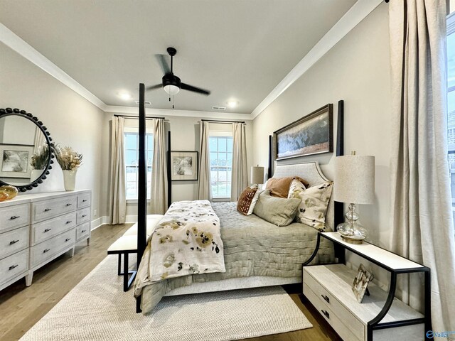 bedroom featuring crown molding, light hardwood / wood-style flooring, and ceiling fan