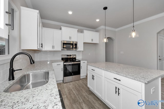 kitchen with a center island, sink, white cabinets, and stainless steel appliances