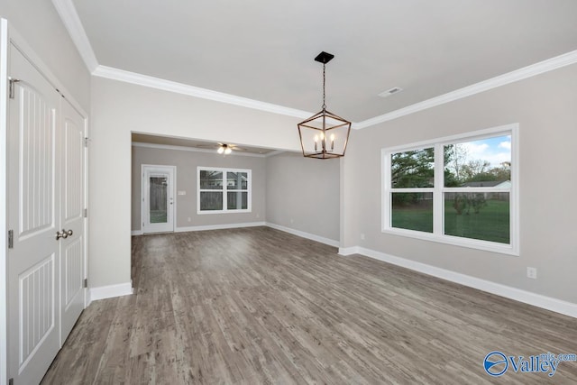 interior space with hardwood / wood-style floors, ceiling fan with notable chandelier, and ornamental molding