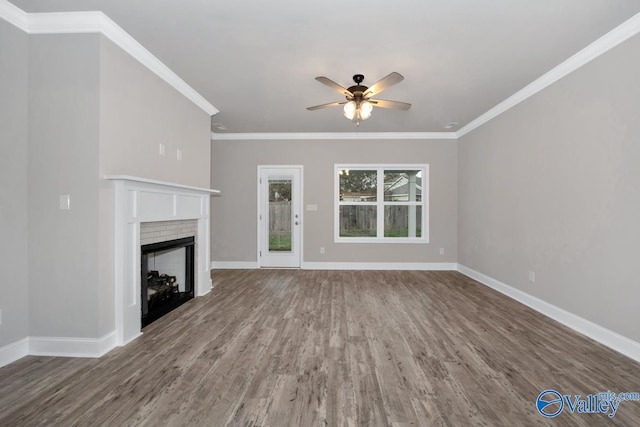 unfurnished living room with a fireplace, hardwood / wood-style flooring, ceiling fan, and crown molding