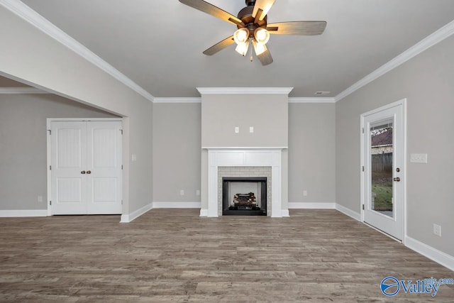 unfurnished living room with a fireplace, hardwood / wood-style flooring, ceiling fan, and crown molding