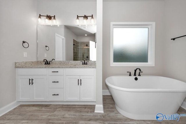 bathroom featuring wood-type flooring, vanity, and shower with separate bathtub