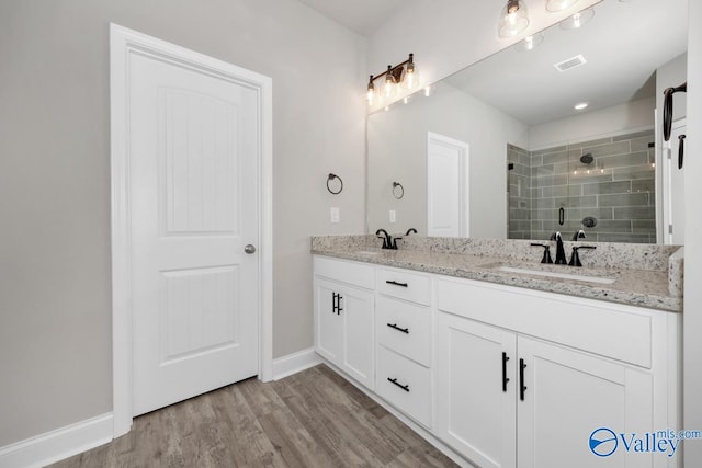 bathroom with walk in shower, vanity, and hardwood / wood-style flooring