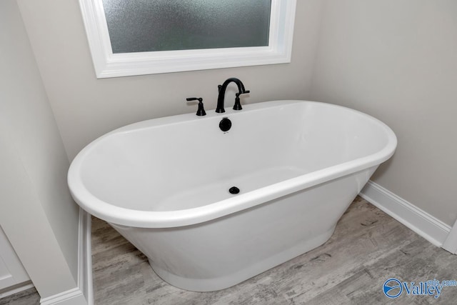 bathroom with a bath and wood-type flooring