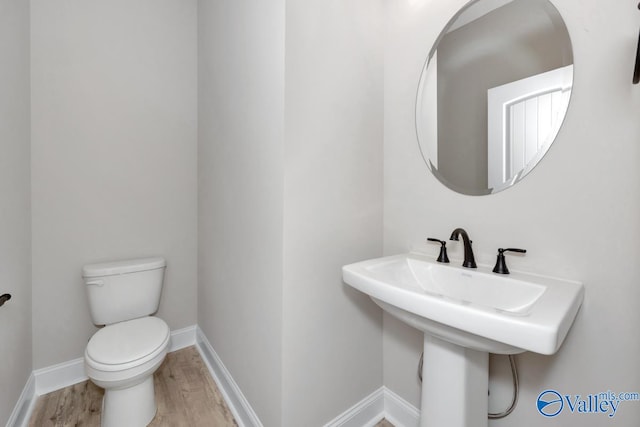 bathroom featuring hardwood / wood-style floors, toilet, and sink