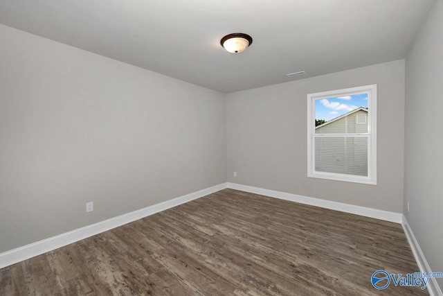 spare room featuring dark wood-type flooring