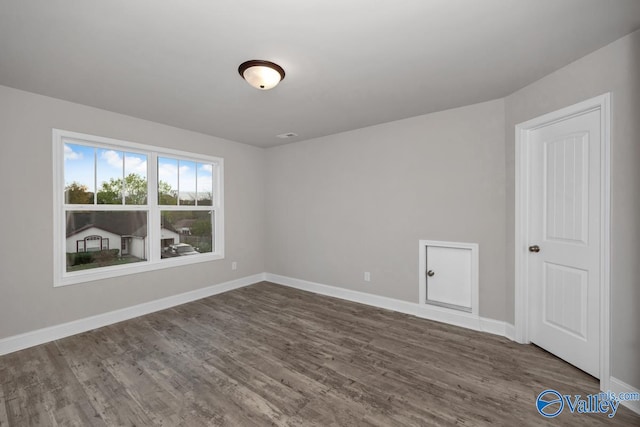 unfurnished room with dark hardwood / wood-style flooring