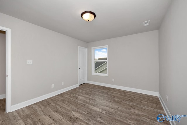 spare room featuring wood-type flooring