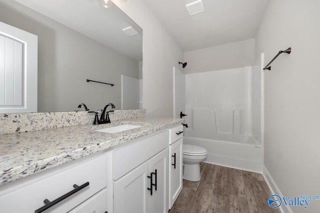 full bathroom featuring hardwood / wood-style floors, vanity, toilet, and shower / washtub combination