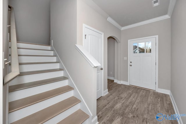 entryway with light hardwood / wood-style floors and ornamental molding