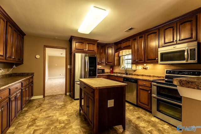 53 Price Mountain Dr, Decatur, AL 35603 - kitchen with appliances with stainless steel finishes, butcher block countertops, a center island, stone finish floors, and baseboards