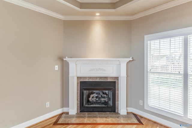 interior details with hardwood / wood-style flooring, crown molding, and a tiled fireplace