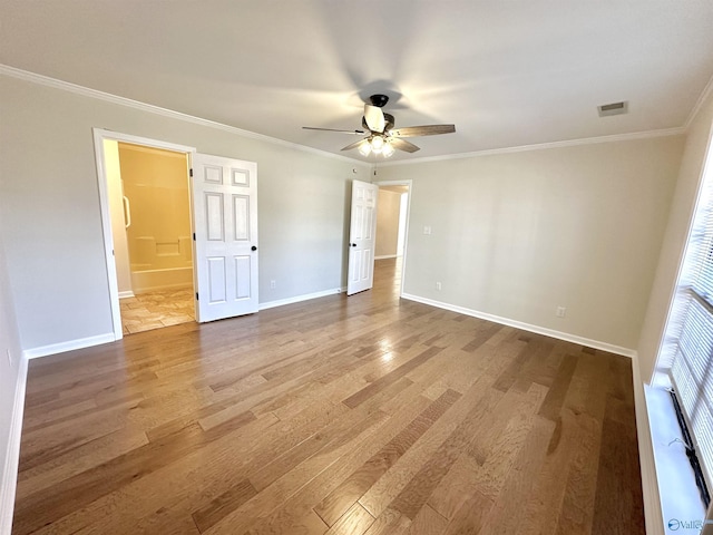 unfurnished bedroom featuring wood-type flooring, ornamental molding, ensuite bathroom, and ceiling fan