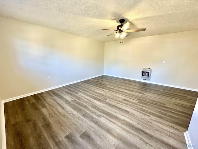 empty room with hardwood / wood-style flooring, heating unit, a textured ceiling, and ceiling fan