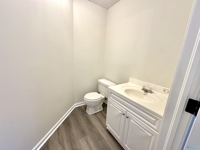 bathroom featuring hardwood / wood-style flooring, vanity, a textured ceiling, and toilet