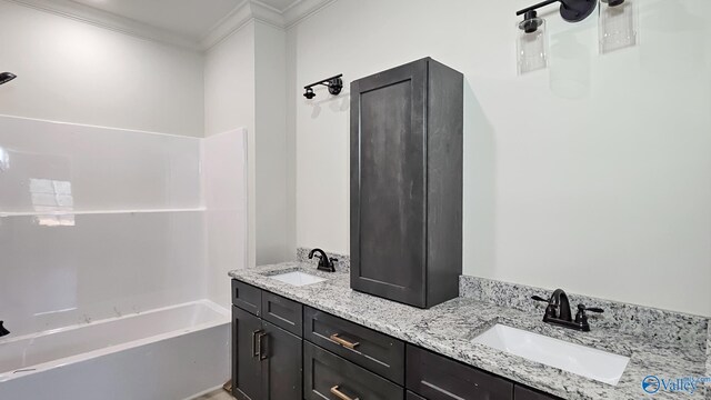 bathroom with double vanity, ornamental molding, bathtub / shower combination, and a sink