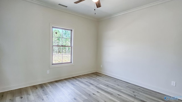 empty room featuring light wood-style flooring, visible vents, baseboards, and crown molding