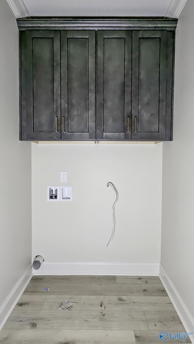 clothes washing area featuring light wood-type flooring, hookup for a washing machine, baseboards, and cabinet space