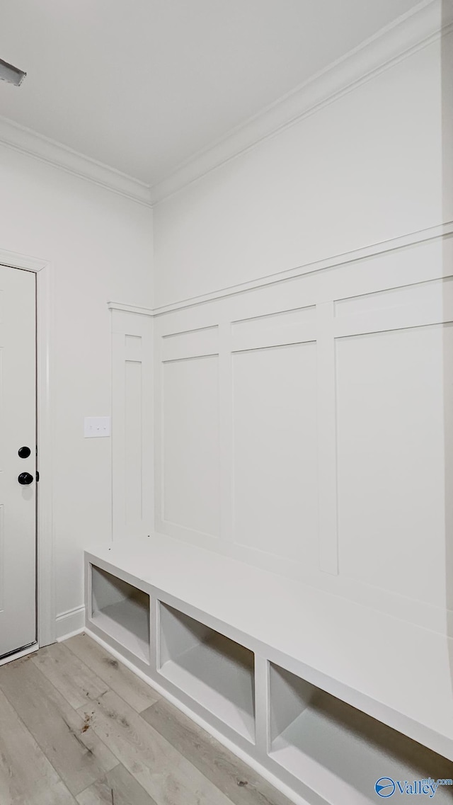 mudroom featuring ornamental molding, visible vents, and light wood-style floors