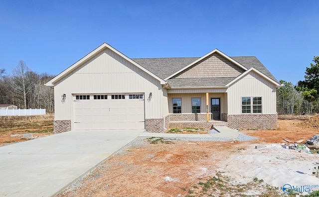 view of front of home featuring a garage, driveway, roof with shingles, and brick siding