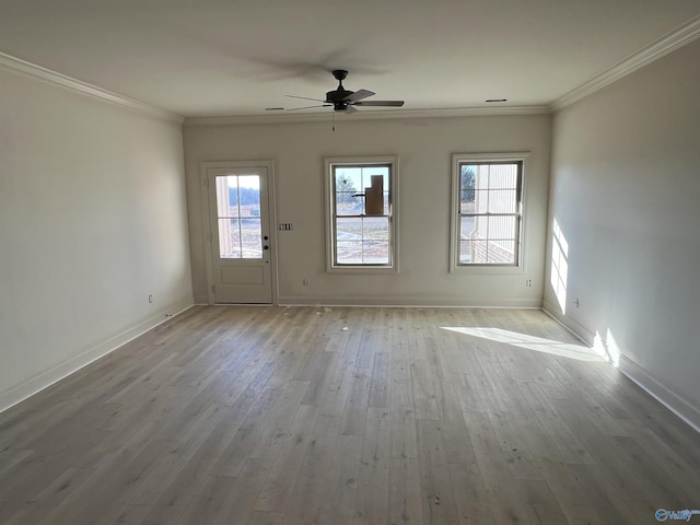 interior space with ceiling fan, ornamental molding, wood finished floors, and baseboards