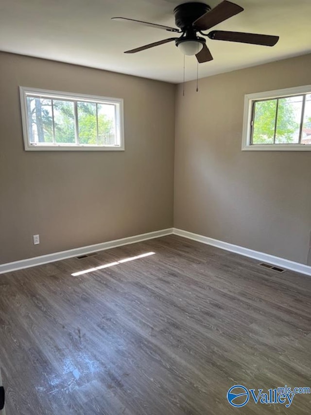 empty room with visible vents, a ceiling fan, baseboards, and plenty of natural light