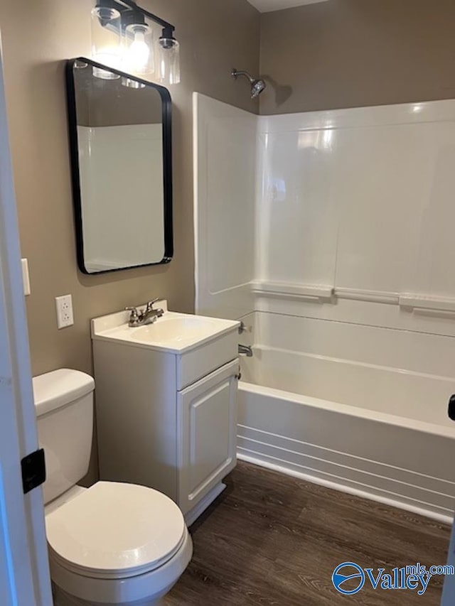 bathroom featuring vanity, toilet, shower / tub combination, and wood finished floors