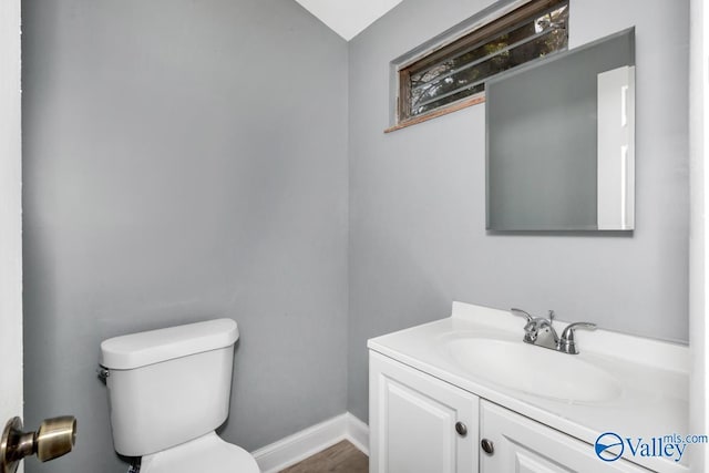 bathroom with vanity, toilet, and baseboards