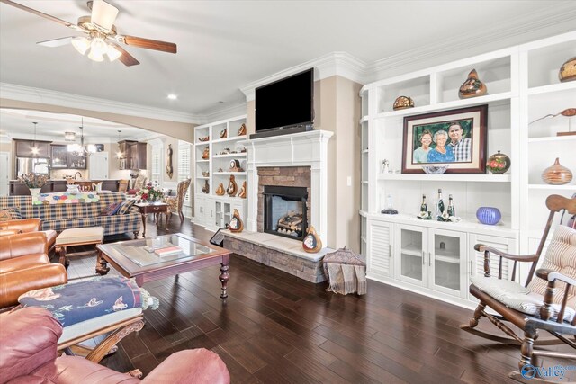 living room featuring a fireplace, dark hardwood / wood-style flooring, ceiling fan, and crown molding