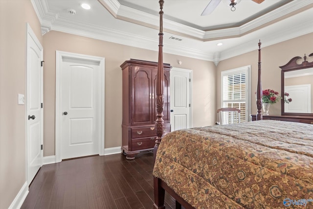 bedroom featuring dark wood-type flooring, a raised ceiling, ceiling fan, and ornamental molding